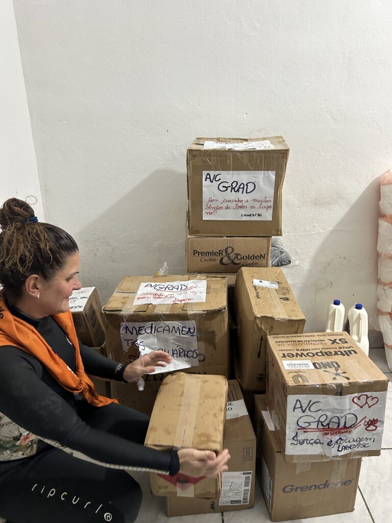 Pilhas de caixas de doações com doações para animais resgatados durante a enchente no Rio Grande do Sul. Essa imagem destaca a generosidade das doações recebidas e o impacto positivo no resgate e cuidado dos animais afetados.